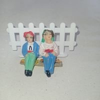 Маленькие Винтажные фигурки, сидящие на скамейке мужчина и женщина, пара.